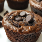 A batch of freshly baked chocolate chip cupcakes topped with creamy vanilla frosting and chocolate drizzle.